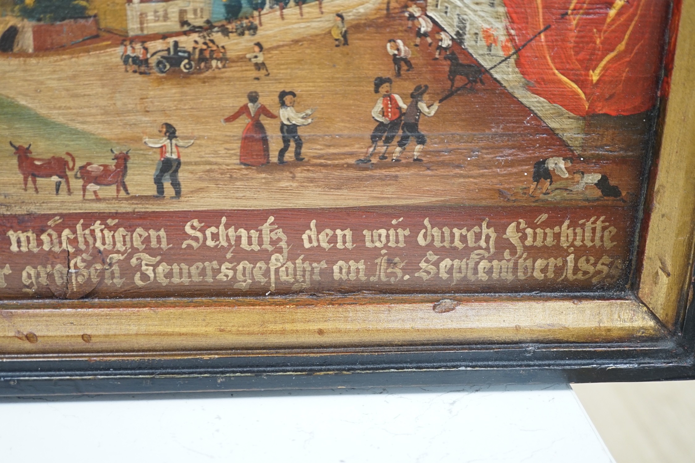 19th century German School, oil on wooden panel, Village scene with figures fire fighting, inscribed and dated 1855, 30 x 47cm